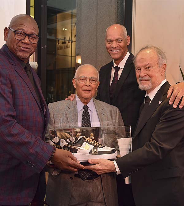 Four honorees, including Dr. Richard Lapchick, pose together with a commemorative award